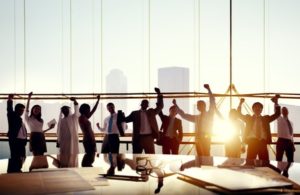 31335635 - group of business people with their arms raised in board room